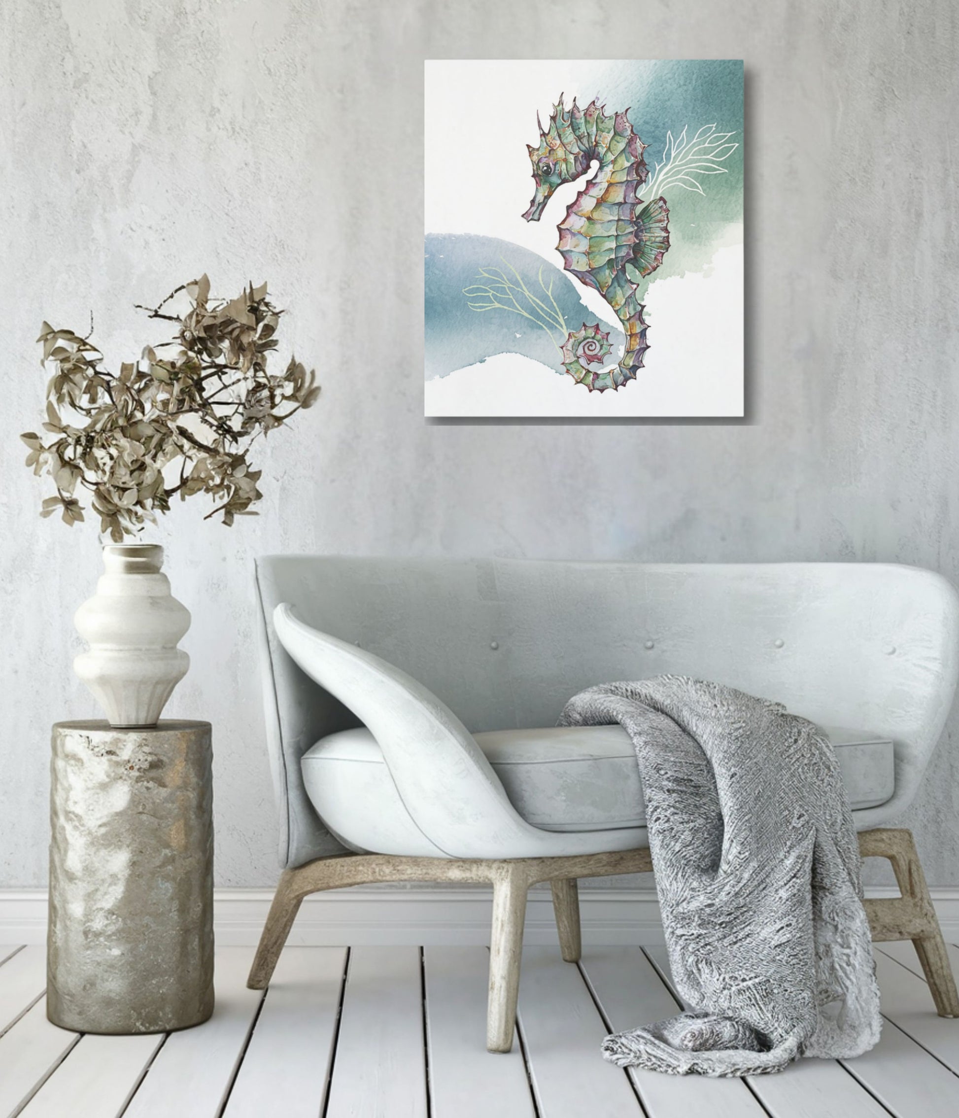 An unframed wall art print featuring a colorful seahorse illustration hanging above a light gray upholstered armchair in a styled interior room with a textured wall, floor lamp, and throw blanket.