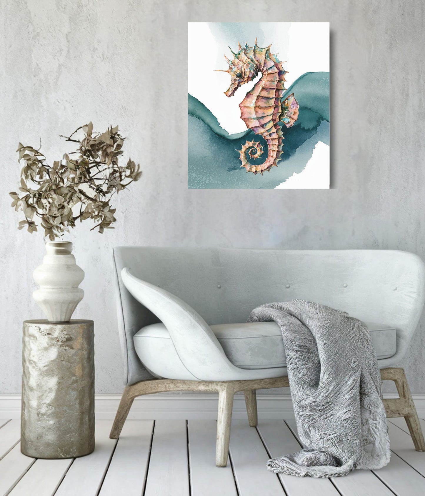 A vertical canvas art print of a seahorse hanging on a textured gray wall above a modern white armchair with a gray throw blanket and a decorative vase.