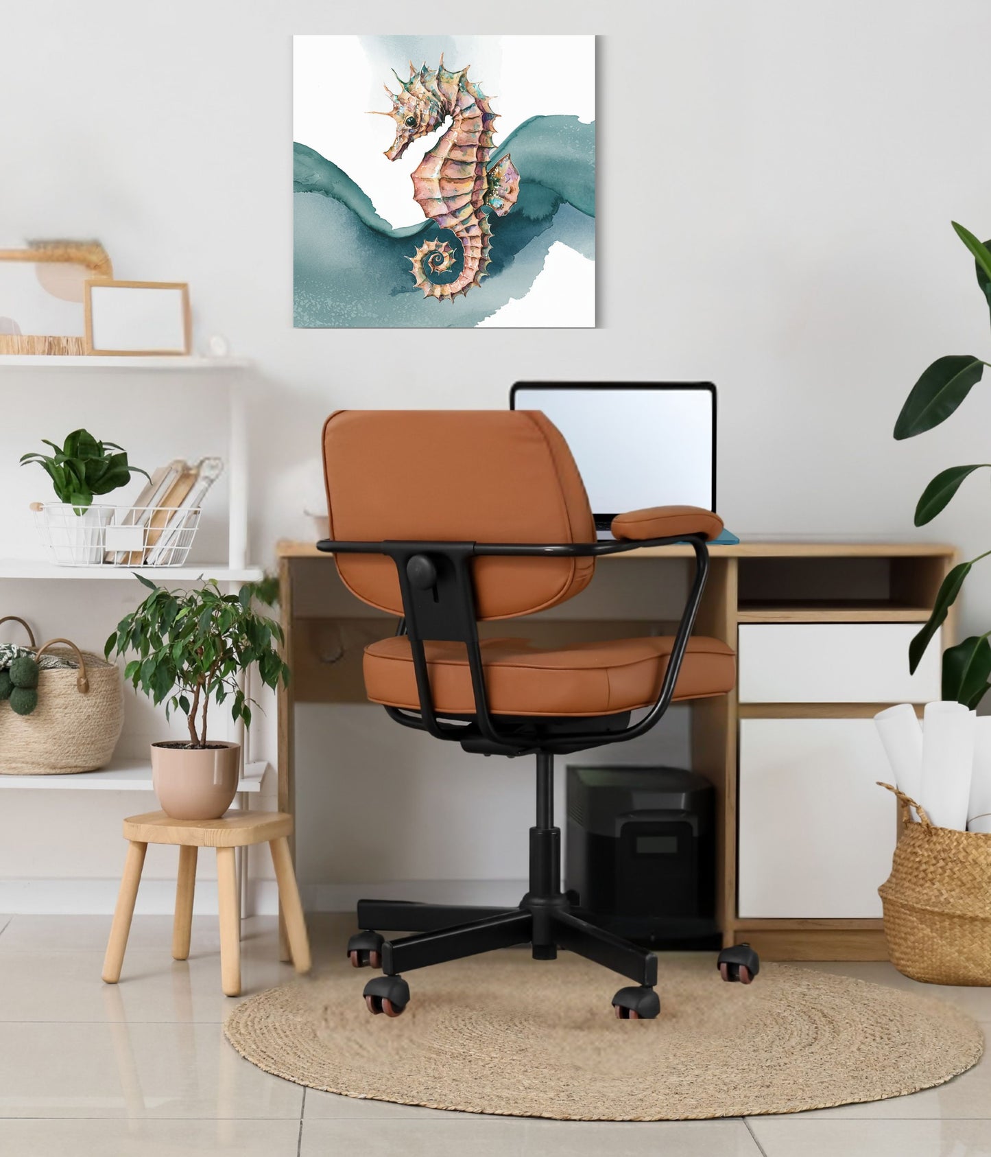 A styled home office scene featuring a brown leather office chair with a black frame, set in front of a wooden desk. The wall behind the desk is decorated with an unframed watercolor print of a seahorse.