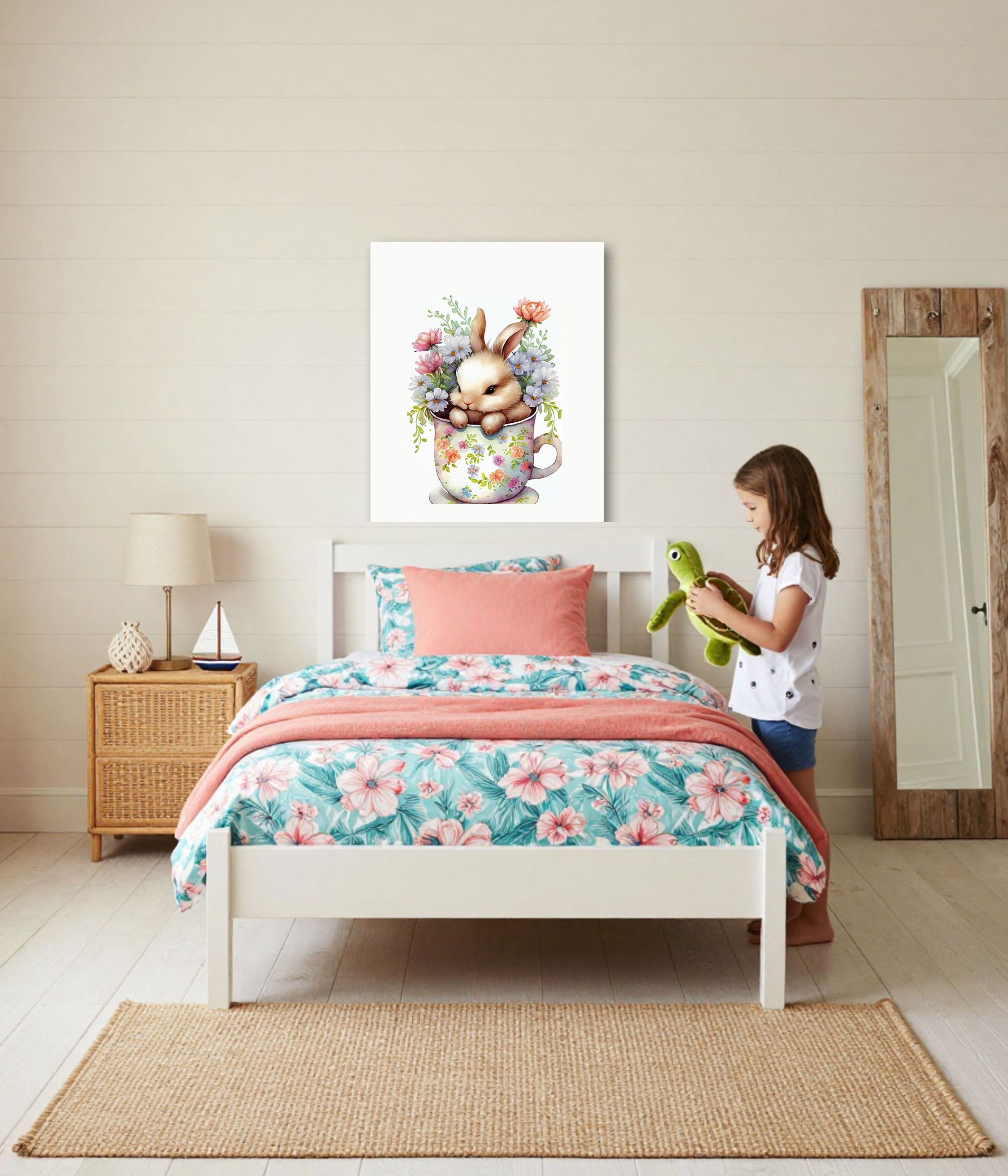 A child's bedroom scene with a white bed dressed in a pink and teal floral print, a coral throw blanket, and a matching pillow. A girl stands beside the bed holding a green plush toy.